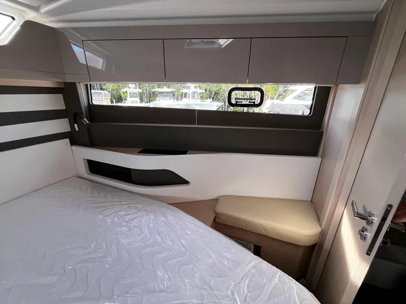 Slide: The Image of 2024 Jeanneau DB/43 OB cabin interior with bed, window, and storage. - 25