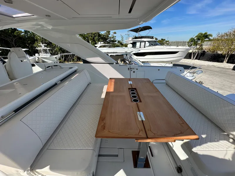 Slide: The Image of 2024 Jeanneau DB/43 OB boat interior with white seating and wooden table. - 8