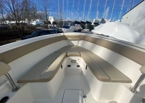 Slide: The Image of 2018 Sailfish 290 CC boat with spacious seating area and beige cushions. - 13
