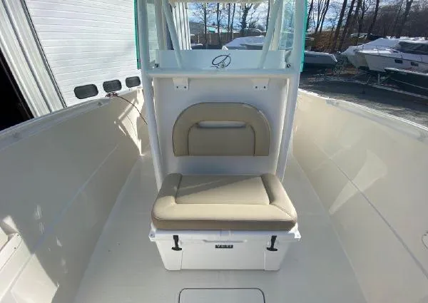 Slide: The Image of 2018 Sailfish 290 CC boat interior with cushioned seating and storage. - 14