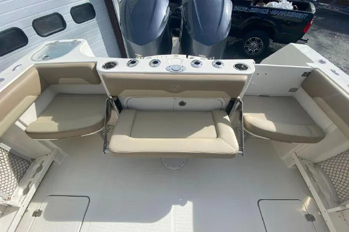 Slide: The Image of 2018 Sailfish 290 CC boat interior with beige seating and twin outboard motors. - 18