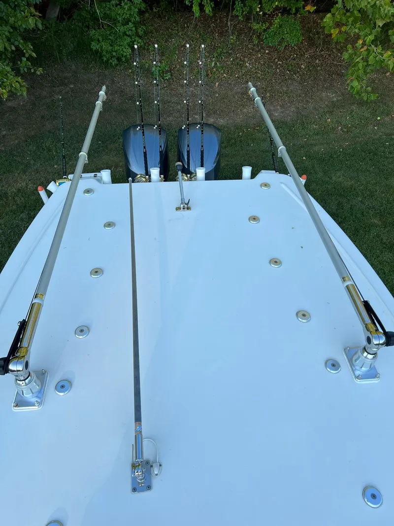 Slide: The Image of 2018 Sailfish 290 CC boat with fishing rods and dual outboard motors. - 22