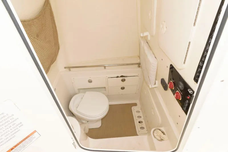 Slide: The Image of 2018 Sailfish 290 CC boat interior bathroom with toilet and storage compartments. - 23