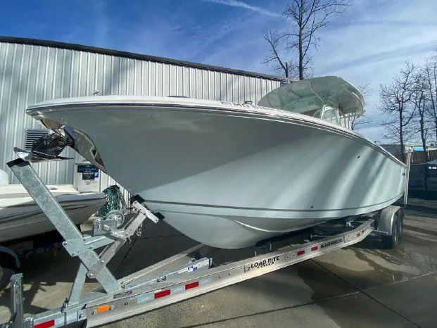 Slide: The Image of 2018 Sailfish 290 CC boat on a trailer, parked outdoors. - 4