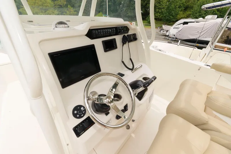 Slide: The Image of 2018 Sailfish 290 CC boat helm with steering wheel, controls, and navigation display. - 9
