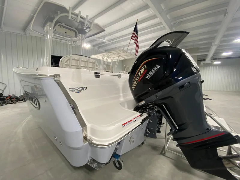 Slide: The Image of 2024 Robalo R230 Center Console boat with Yamaha outboard motor in a storage facility. - 2