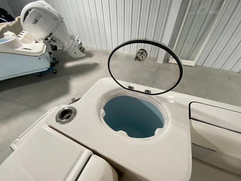 Slide: The Image of 2024 Robalo R230 Center Console boat with open livewell and outboard motor. - 6