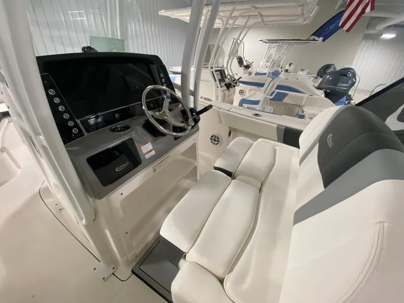 Slide: The Image of 2024 Robalo R230 Center Console boat interior with steering wheel and seating. - 8