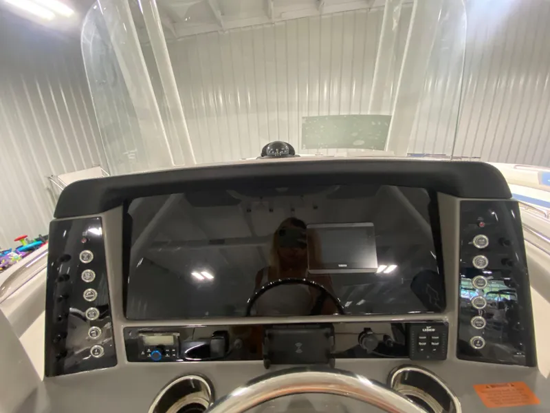 Slide: The Image of 2024 Robalo R230 Center Console boat dashboard with modern controls and steering wheel. - 11