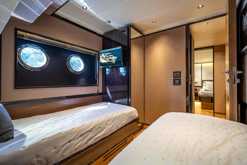 Slide: The Image of Luxurious cabin interior of 2022 Absolute Navetta 73 yacht with twin beds and porthole windows. - 32