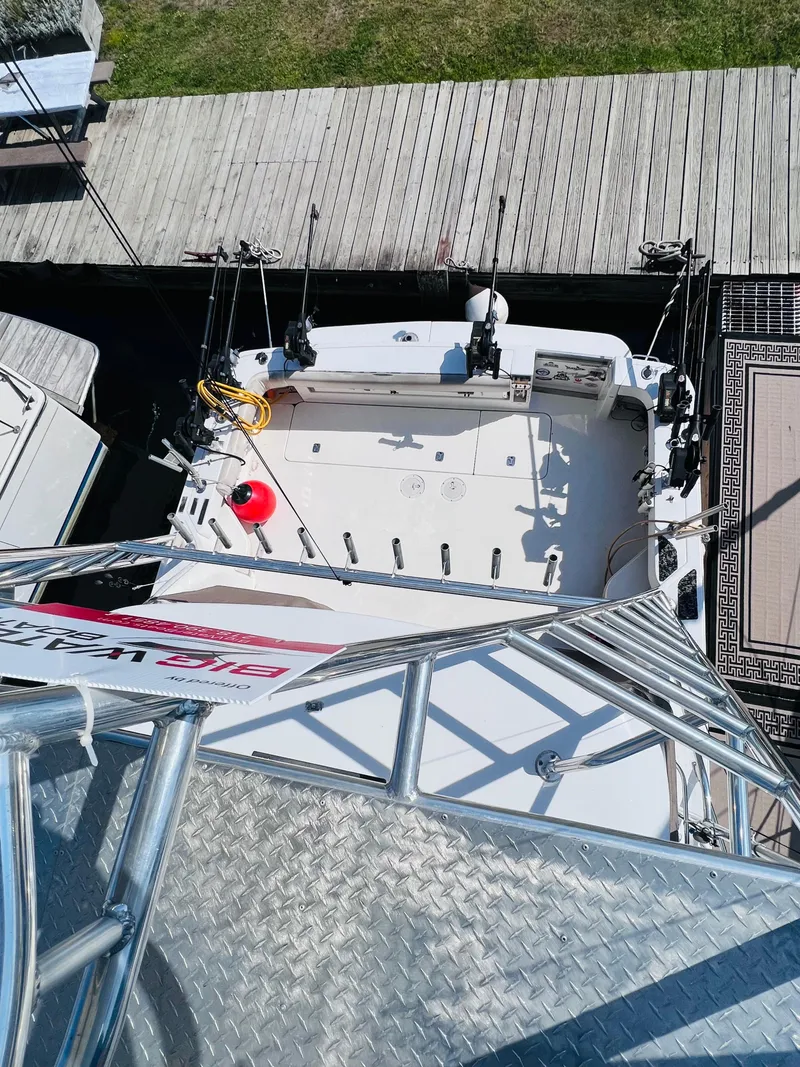Slide: The Image of 1998 Sea Ray Express Cruiser docked, viewed from above, showcasing fishing rods and deck layout. - 13