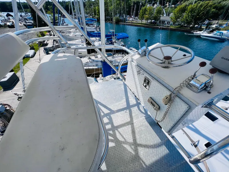 Slide: The Image of 1998 Sea Ray Express Cruiser helm with steering wheel and controls, docked at a marina. - 14