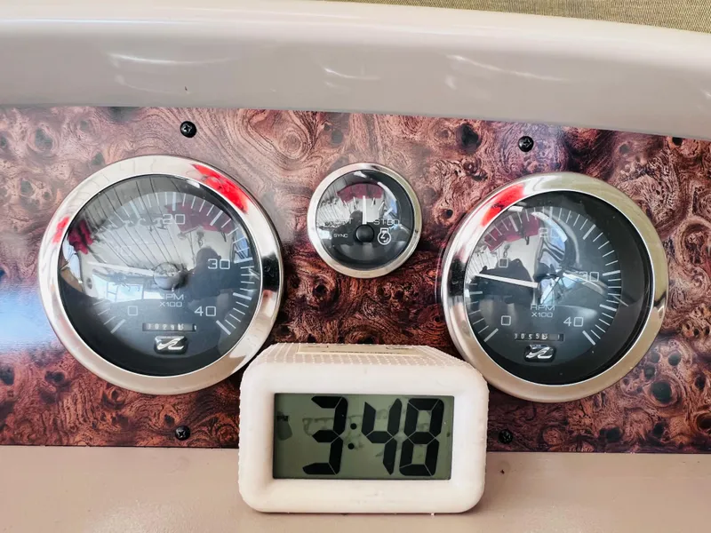 Slide: The Image of 1998 Sea Ray Express Cruiser dashboard with gauges and digital clock displaying 3:48. - 20