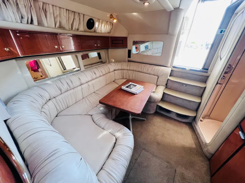 Slide: The Image of Luxurious 1998 Sea Ray Express Cruiser interior with plush seating and wooden table. - 21