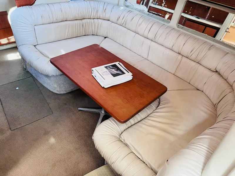 Slide: The Image of Interior of 1998 Sea Ray Express Cruiser with plush seating and wooden table. - 22
