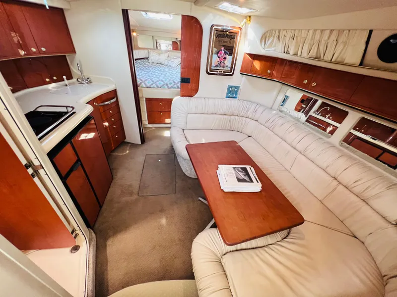 Slide: The Image of 1998 Sea Ray Express Cruiser interior with kitchen, dining area, and cozy seating. - 23