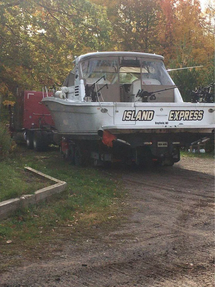 Slide: The Image of 1998 Sea Ray Express Cruiser "Island Express" on trailer, surrounded by autumn foliage. - 30