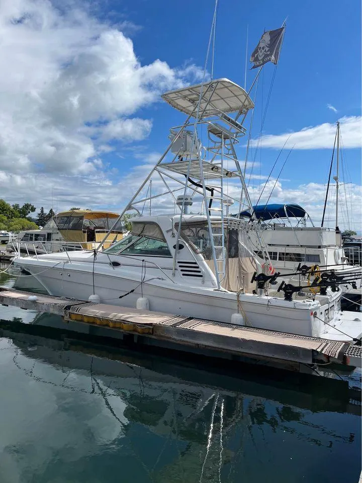 Slide: The Image of 1998 Sea Ray Express Cruiser docked at marina under blue sky. - 4