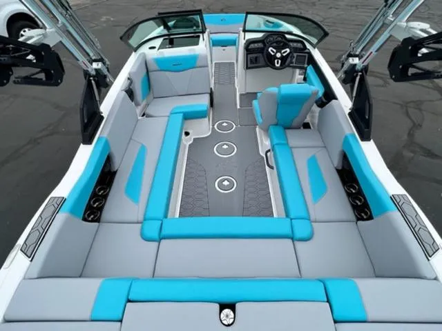 Slide: The Image of 2023 MasterCraft NXT22 boat interior with blue and gray seating, modern dashboard, and spacious layout. - 10