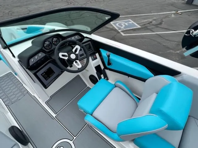 Slide: The Image of 2023 MasterCraft NXT22 boat interior with blue and gray seating and modern dashboard. - 11