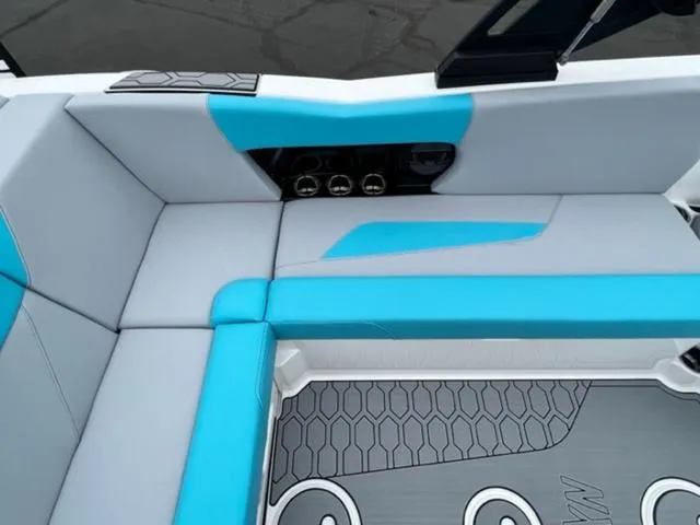 Slide: The Image of 2023 MasterCraft NXT22 boat interior with blue and gray seating and hexagonal floor pattern. - 13