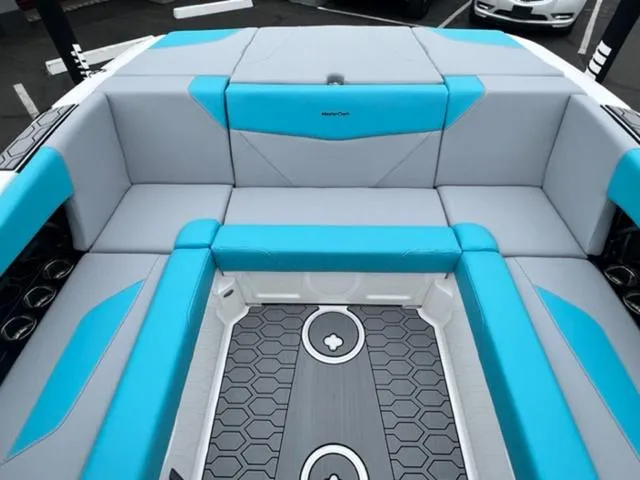 Slide: The Image of 2023 MasterCraft NXT22 boat interior with blue and gray seating and hexagonal floor design. - 14