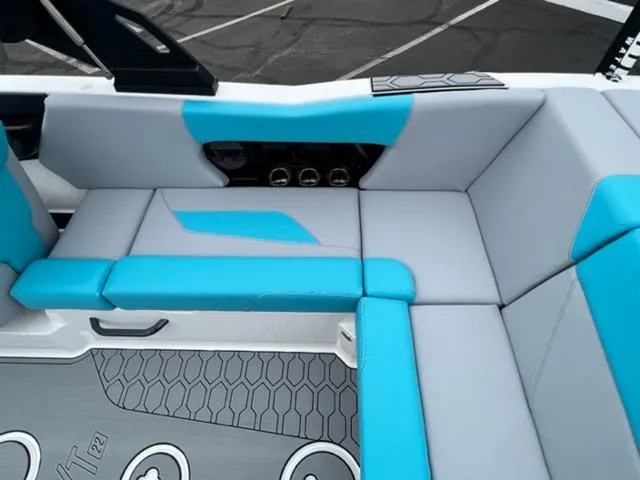Slide: The Image of 2023 MasterCraft NXT22 boat interior with blue and gray seating and modern design. - 15