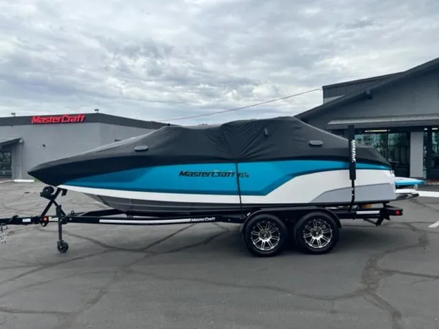 Slide: The Image of 2023 MasterCraft NXT22 boat with cover on trailer, parked outside dealership. - 19