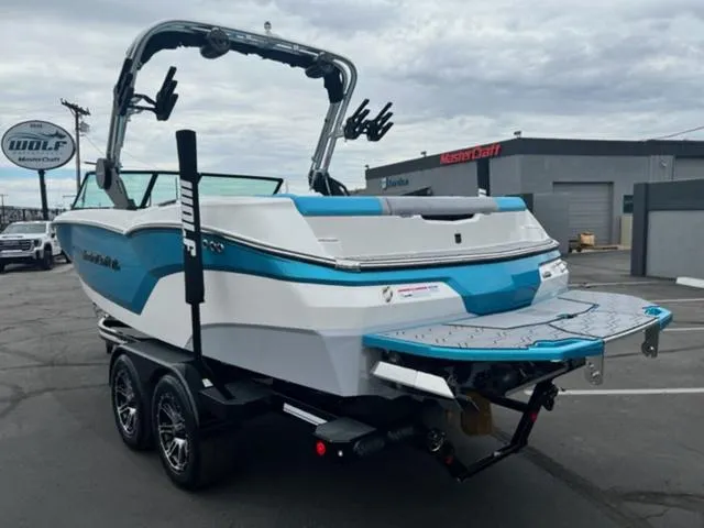 Slide: The Image of 2023 MasterCraft NXT22 boat on trailer, blue and white design, parked at dealership. - 8