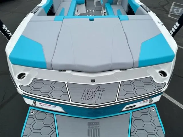 Slide: The Image of 2023 MasterCraft NXT22 boat with blue and gray seating and hexagonal design accents. - 9