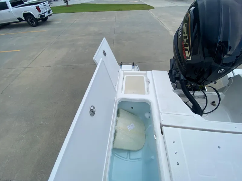 Slide: The Image of 2024 Robalo 246 Cayman boat with open storage compartments and outboard motor. - 10