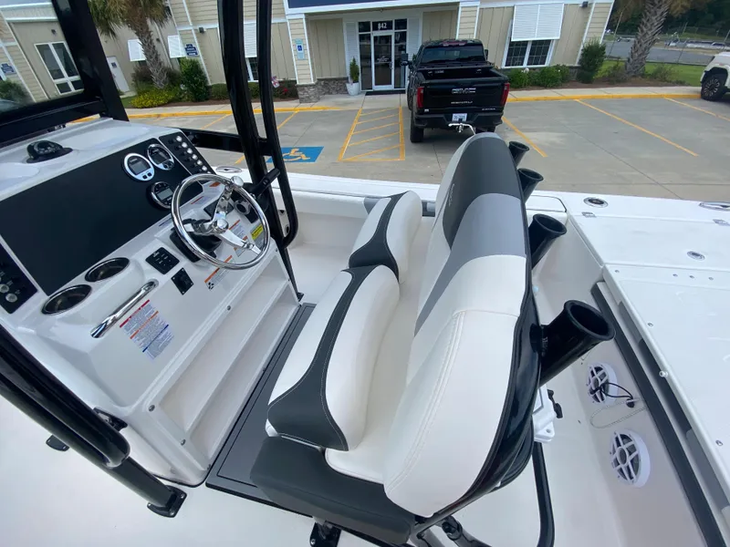 Slide: The Image of 2024 Robalo 246 Cayman boat cockpit with steering wheel and seating. - 12