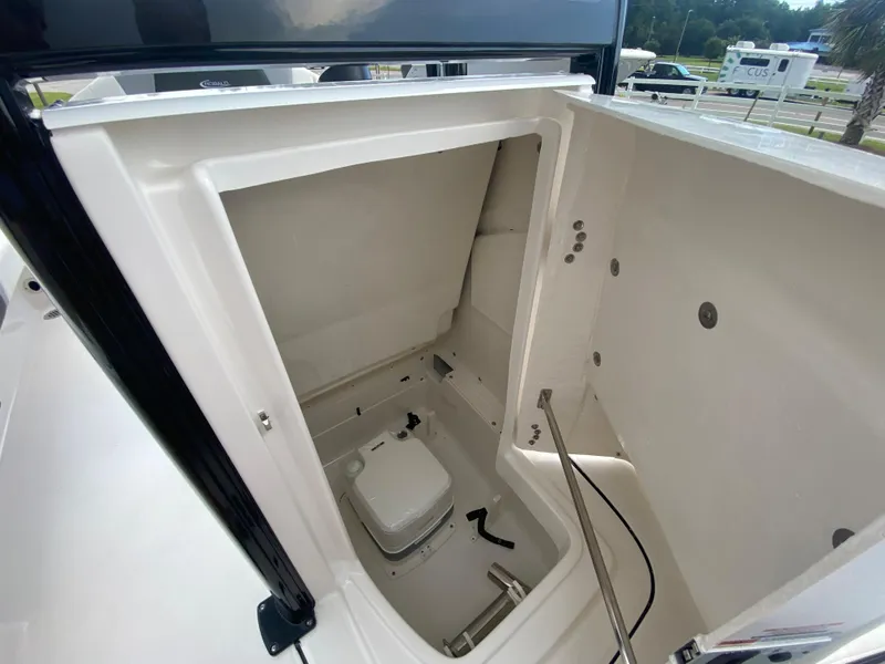Slide: The Image of 2024 Robalo 246 Cayman boat storage compartment with built-in toilet. - 19