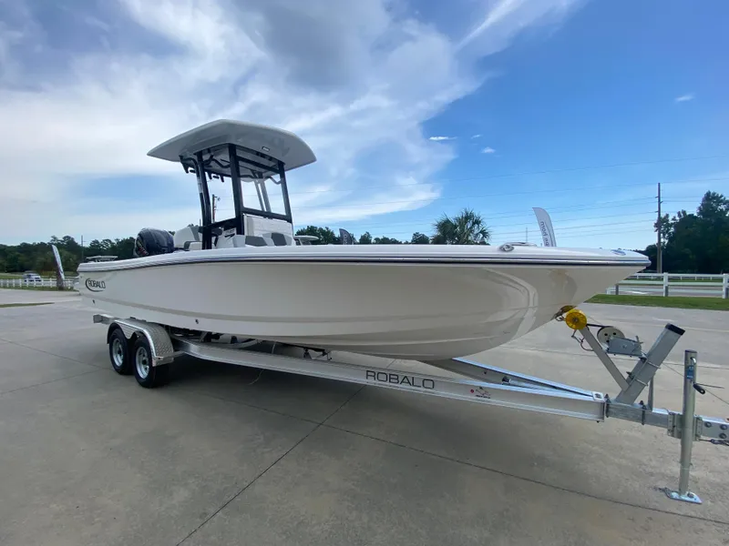 Slide: The Image of 2024 Robalo 246 Cayman boat on a trailer under a blue sky. - 2