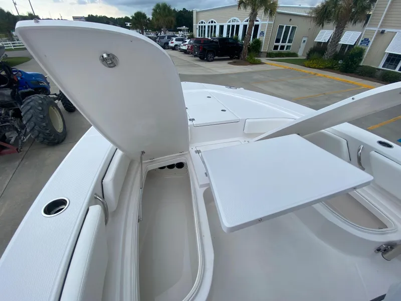 Slide: The Image of 2024 Robalo 246 Cayman boat with open storage compartments and seating area. - 23