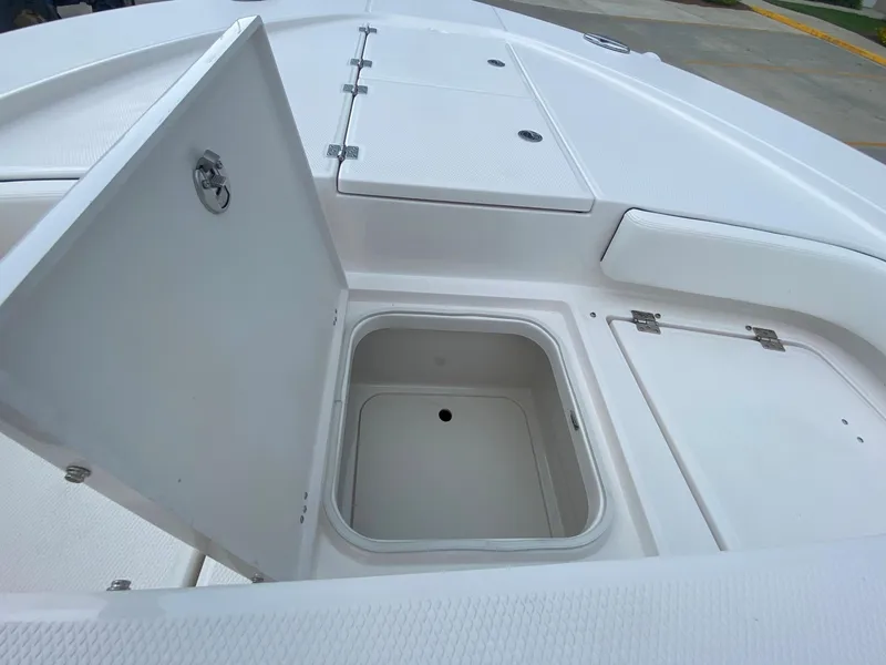 Slide: The Image of 2024 Robalo 246 Cayman boat storage compartments and hatches. - 24