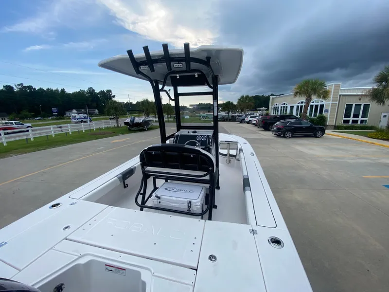 Slide: The Image of 2024 Robalo 246 Cayman boat, white exterior, parked outdoors on a cloudy day. - 7