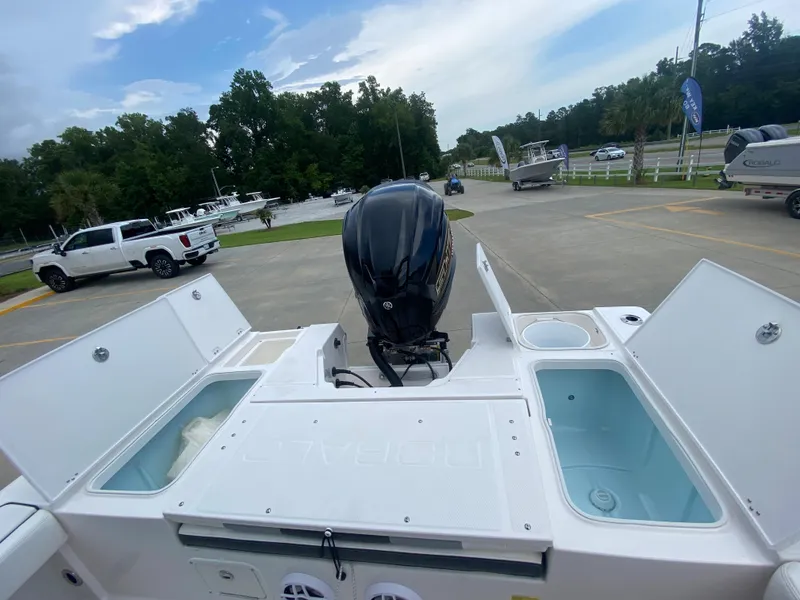 Slide: The Image of 2024 Robalo 246 Cayman boat with open storage compartments and outboard motor. - 8