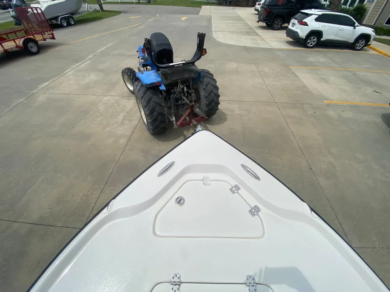 Slide: The Image of 2024 Key West 210 Bay Reef boat being towed by a blue tractor. - 22