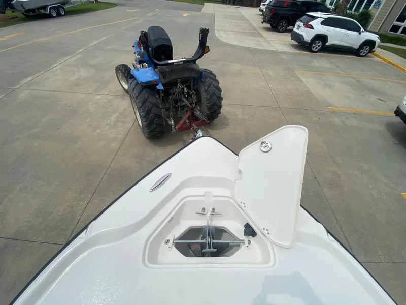 Slide: The Image of 2024 Key West 210 Bay Reef boat being towed by a blue tractor in a parking lot. - 23