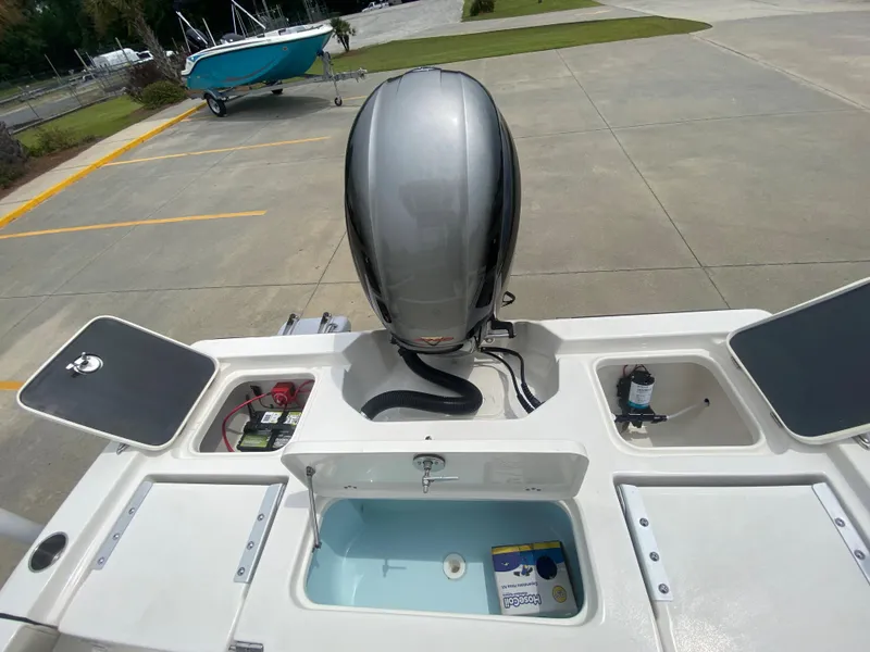Slide: The Image of 2024 Key West 210 Bay Reef boat with outboard motor and storage compartments. - 7