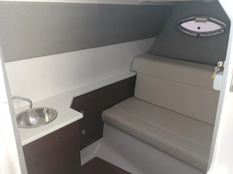 Slide: The Image of 2024 Chaparral 280 OSX cabin interior with seating and sink. - 11