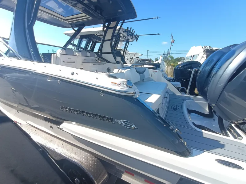 Slide: The Image of 2024 Chaparral 280 OSX boat with sleek design and powerful engines, docked under clear skies. - 27