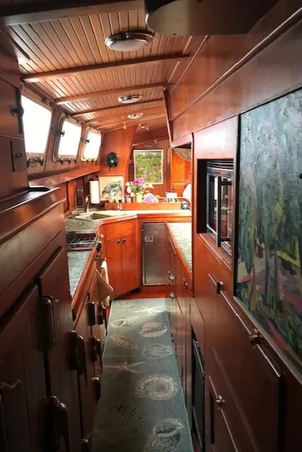 Slide: The Image of Interior of 1983 Stuart Marine 62 Custom Ketch with wood paneling and cozy kitchen area. - 11