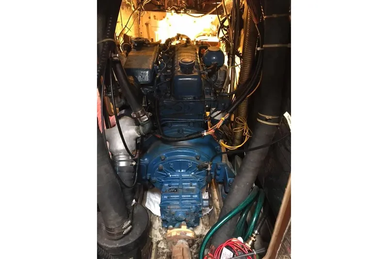Slide: The Image of Engine room of 1983 Stuart Marine 62 Custom Ketch, featuring a blue marine engine. - 14