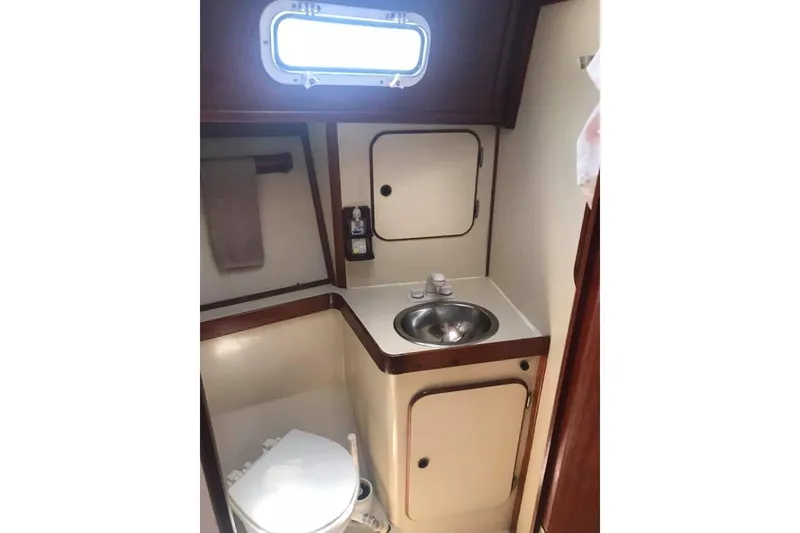 Slide: The Image of Compact bathroom in 1983 Stuart Marine 62 Custom Ketch, featuring sink and toilet. - 20