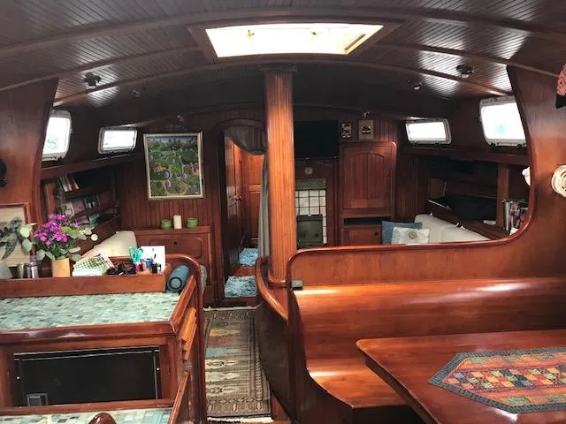 Slide: The Image of Interior of 1983 Stuart Marine 62 Custom Ketch, featuring wood paneling and cozy seating area. - 4