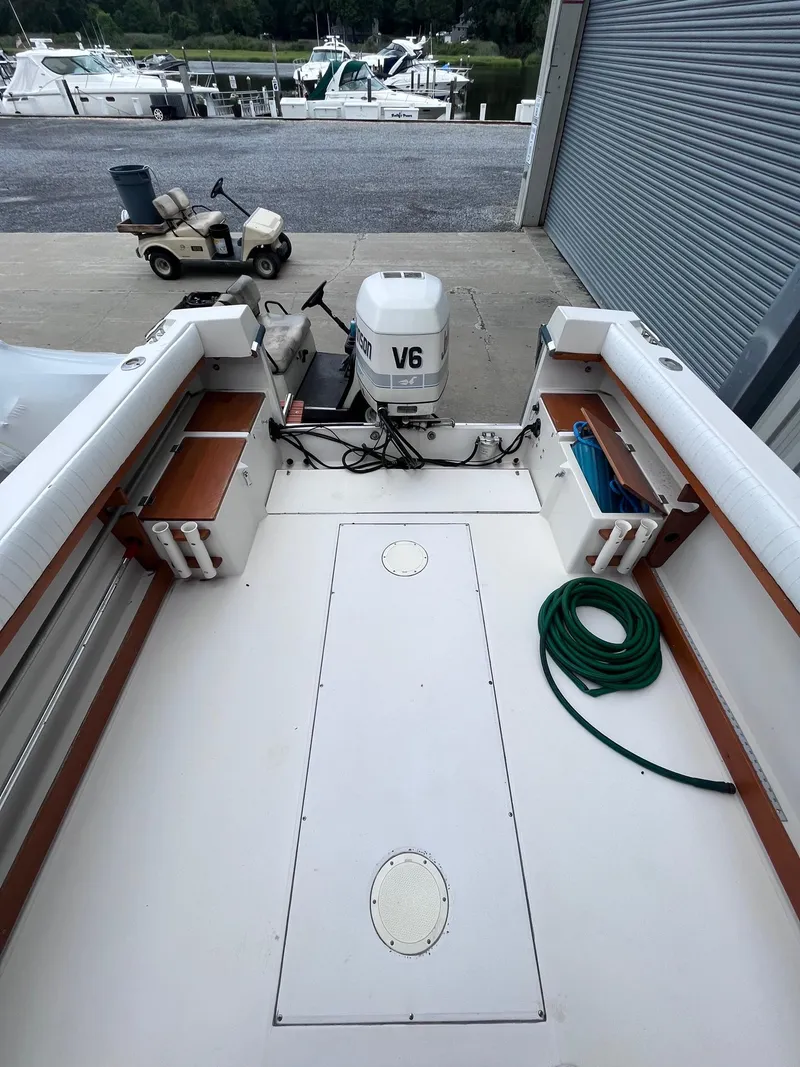 Slide: The Image of 1987 Grady-White 24 Offshore boat interior with V6 engine and dockside view. - 1