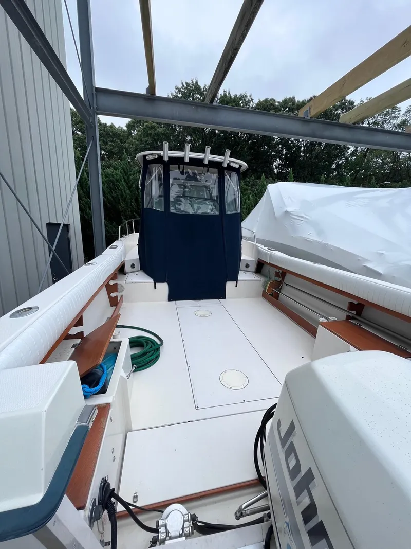 Slide: The Image of 1987 Grady-White 24 Offshore boat with covered cockpit and outboard motor. - 13