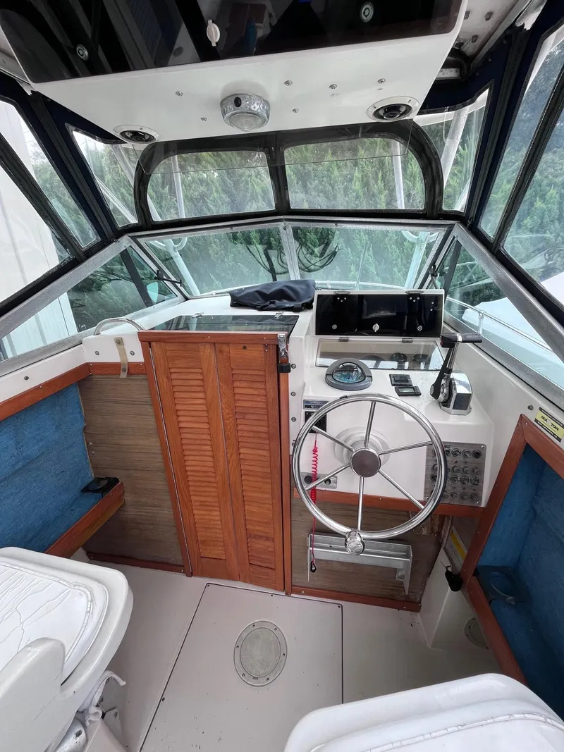 Slide: The Image of 1987 Grady-White 24 Offshore boat cockpit with steering wheel and wooden accents. - 3
